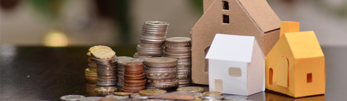 coins on a table next to paper houses